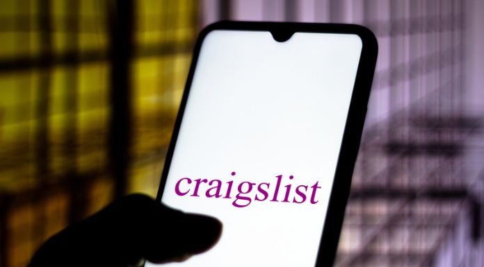 Person's hand holding a phone with Craigslist's logo on the screen