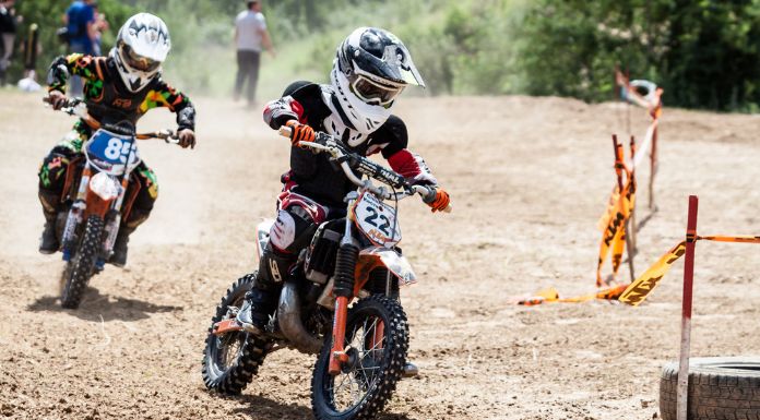 2 kids onriding their dirt bike on a motocross racinig